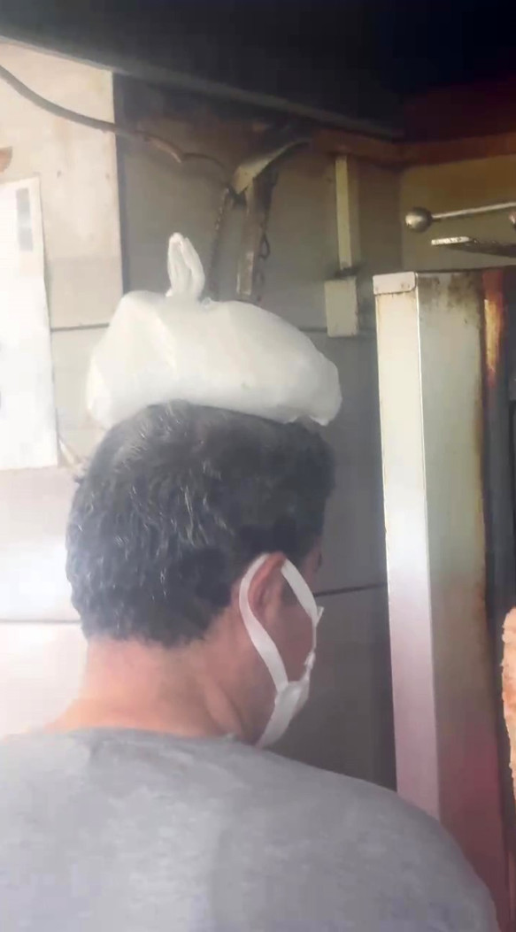 Dönerci ustası kavurucu sıcakta, ateş karşısında kafasına buz torbası koyarak serinlemeye çalıştı - Resim : 1