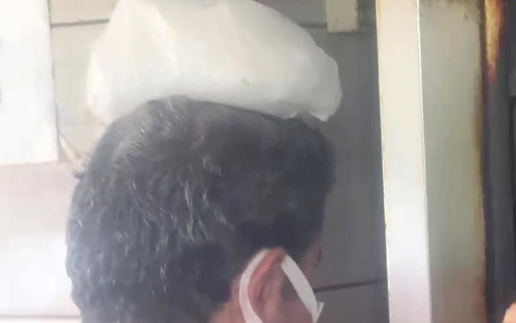 Dönerci ustası kavurucu sıcakta, ateş karşısında kafasına buz torbası koyarak serinlemeye çalıştı