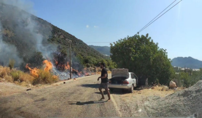Yol kenarındaki yangını gören tatilci aile alevlere müdahale etti