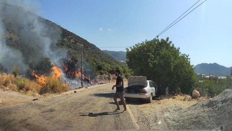 Yol kenarındaki yangını gören tatilci aile alevlere müdahale etti